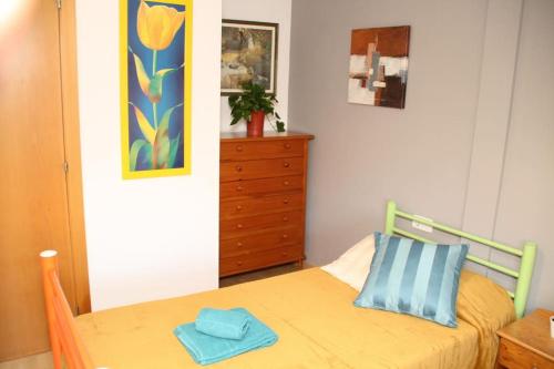 a bedroom with a bed and a dresser with a blue pillow at My Home in Igualada in Igualada