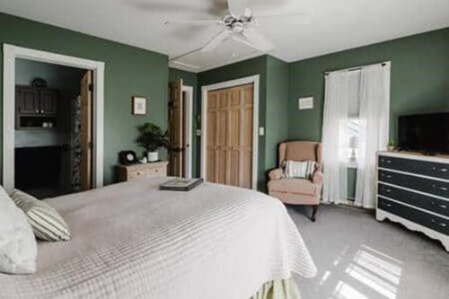 的住宿－Paper Mill Pines Bed and Breakfast，卧室设有白色的床和绿色的墙壁