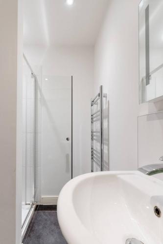 a white bathroom with a sink and a shower at Modern apartment with terrace in Bristol
