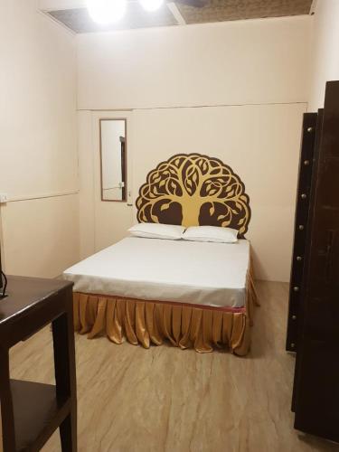 - une chambre avec un lit doté d'une grande tête de lit dans l'établissement Chhoti Kothi - A Heritage Homestay by the Ganges, à Prayagraj