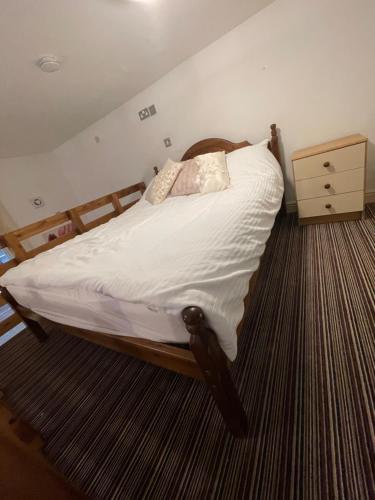 a bedroom with a bed with white sheets and pillows at Mezz Apartment Four in Hull