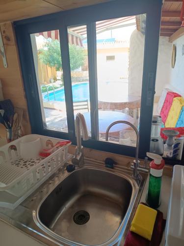 een gootsteen met een droogrek naast een raam bij Tiny House: The Housje in Puerto de la Cruz