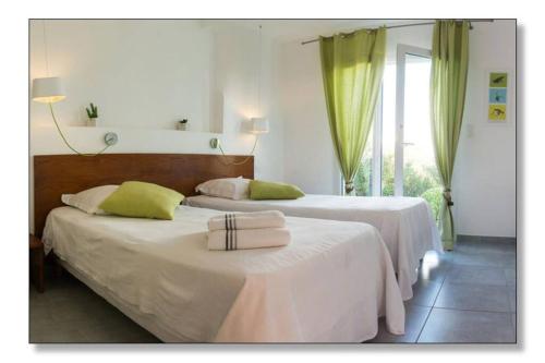 - 2 lits dans une chambre d'hôtel dotée de rideaux verts dans l'établissement Villa St Pierre bord de mer, 6 vélos, climatisation, Jacuzzi, à Sète
