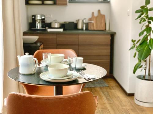 a table with cups and saucers on it in a kitchen at Apartment Loft Lomnica in Tatranská Lomnica