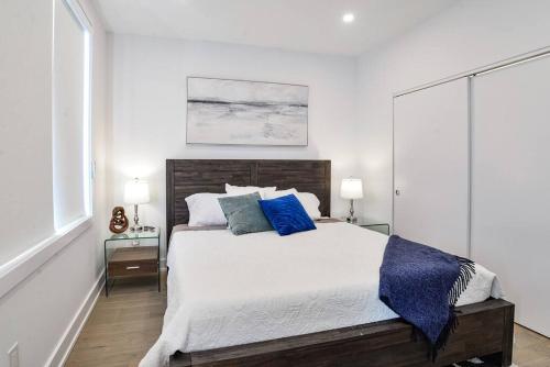 - une chambre blanche avec un grand lit et des oreillers bleus dans l'établissement Luxury Resort Villa in Muskoka, à Gravenhurst