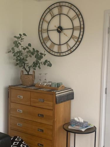 a clock hanging on a wall above a dresser at Cedar Cabin in Newbury