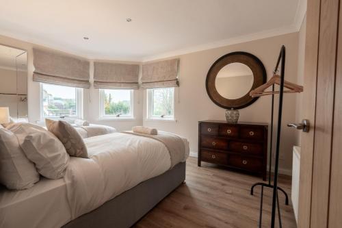 sypialnia z łóżkiem z lustrem i komodą w obiekcie Steels cross House w mieście Lanark