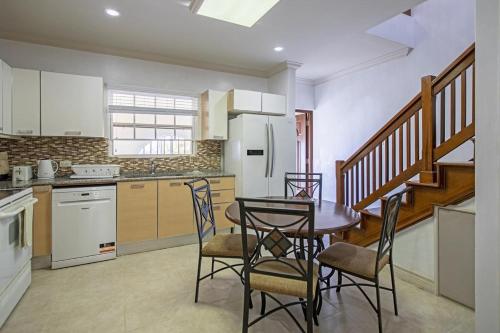 a kitchen with a table and chairs in a room at Whitesands G4 by Barbados Sothebys International Realty in Saint Peter