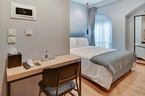 um quarto com uma cama e uma secretária com uma cadeira em 43 Ave em Ioannina
