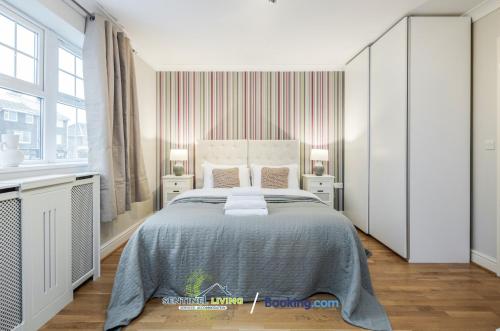 a bedroom with a large bed and two windows at Pet Friendly Spacious Townhouse By Sentinel Living Short Lets & Serviced Accommodation Windsor Ascot Maidenhead With Free Parking in Winkfield