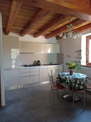 a kitchen with a table with chairs and a dining room at CHALET MIELE in Argegno