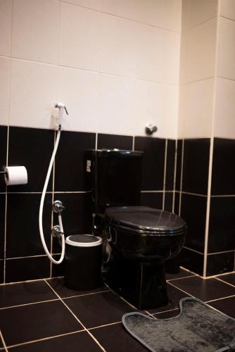 a bathroom with a black toilet and a shower at Munir’s residence in Cairo