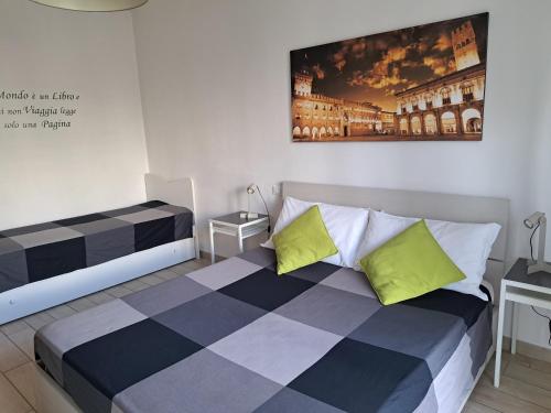 ボローニャにあるBolognamania Apartments-Primeのベッドルーム1室(ベッド2台付)が備わります。壁には絵画が飾られています。