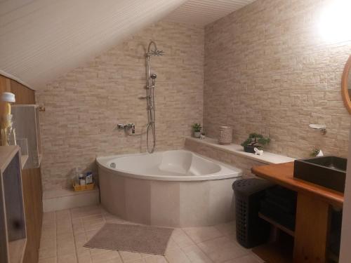 een badkamer met een groot bad en een douche bij Ti Cozy in Baie-Mahault