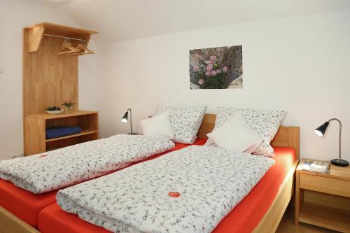 two beds in a small room with two lamps at Ferienhaus Murmel in Ruhpolding