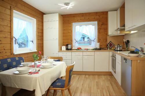 a kitchen with a table with a white tablecloth on it at Ferienhaus Murmel in Ruhpolding