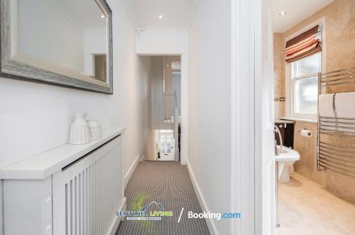 a bathroom with a hallway with a sink and a mirror at Beautiful 3 BDR House in Windsor Town By Sentinel Living Short Lets & Serviced Accommodation Windsor Ascot Maidenhead With Pet Friendly & Superfast Wifi in Windsor