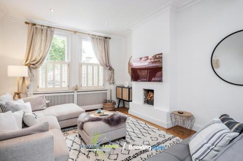 a living room with a couch and a fireplace at Beautiful 3 BDR House in Windsor Town By Sentinel Living Short Lets & Serviced Accommodation Windsor Ascot Maidenhead With Pet Friendly & Superfast Wifi in Windsor