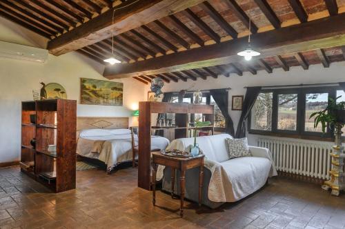 a bedroom with a bed and a couch and a table at Il Saragio in Abbadia di Montepulciano