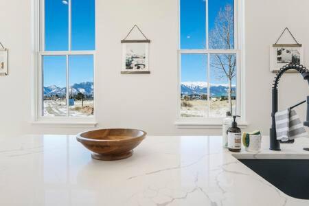 ein Badezimmer mit einer Holztasche, einem Waschbecken und Fenstern in der Unterkunft Alpine Estate 3 Kitchens & Mountain Views in Buena Vista