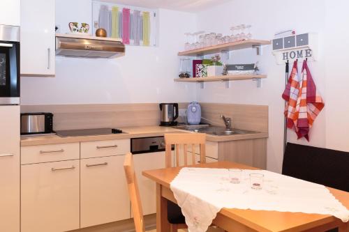 a small kitchen with a table and a small kitchen with a table and a table at Appartement Wöhrer in Schladming