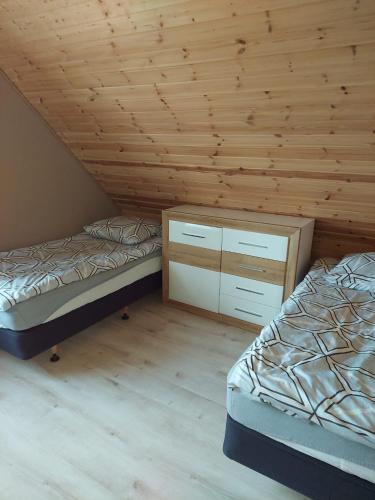 a room with two beds and a wooden ceiling at Domki u Justyny Podgórzyn Karpacz Sosnówka in Podgórzyn