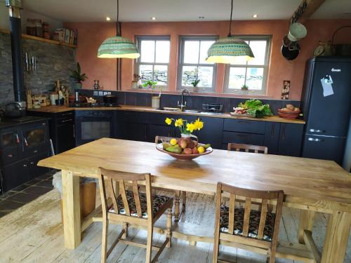 uma cozinha com uma mesa de madeira com uma taça de fruta em Ballimackillichan Croft 