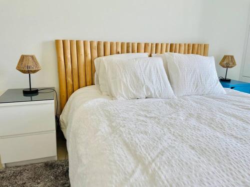 a bedroom with a bed with white sheets and two lamps at Cosy one bedroom Flat in Center with Terrace&Parking in Luxembourg