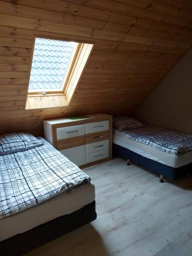 a attic bedroom with two beds and a window at Domki u Justyny Podgórzyn Karpacz Sosnówka in Podgórzyn