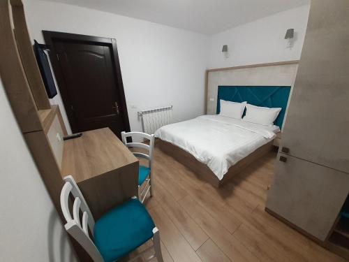 a small bedroom with a bed and a table and chair at Pensiunea Stefania in Lacu Rosu