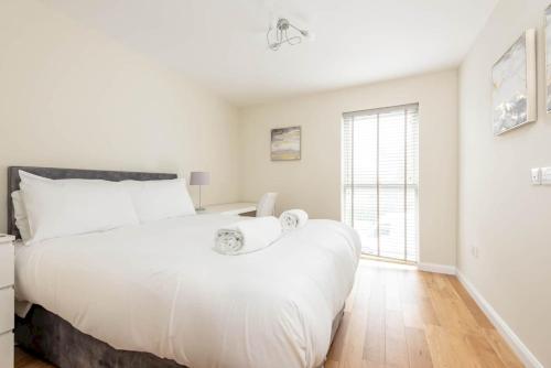 ein Schlafzimmer mit einem großen weißen Bett und einem Fenster in der Unterkunft Argyle Rigg - Central Elegant Townhouse - Balcony in St Andrews
