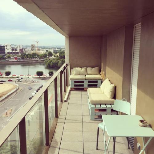 d'un balcon avec des chaises et des tables offrant une vue sur la ville. dans l'établissement Appartement idéal JO à 10 min de Paris (metro 14), à Saint-Ouen