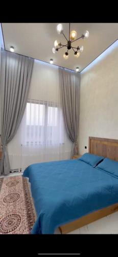 sypialnia z niebieskim łóżkiem i oknem w obiekcie Зона отдыха в горах w mieście Birgulyuk