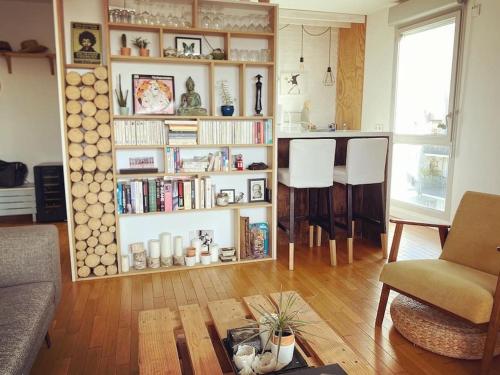 un salon avec une étagère remplie de livres dans l'établissement Appartement idéal JO à 10 min de Paris (metro 14), à Saint-Ouen