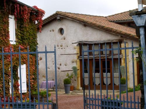 a house with a blue gate in front of it at La Grange in Coutouvre