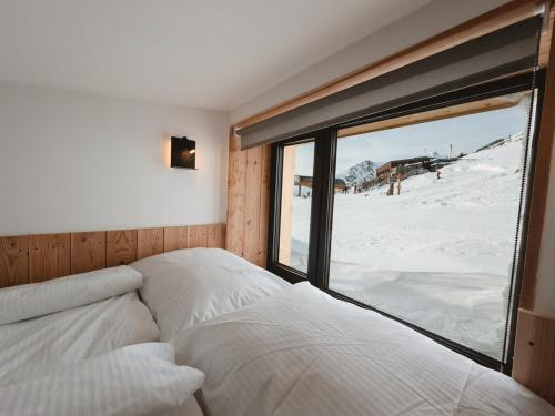 a bedroom with a bed and a view of a snow covered mountain at Horská Chata pod Soliskom in Vysoké Tatry
