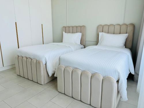 duas camas sentadas uma ao lado da outra num quarto em Luxury Brand New 2 Br Apartment In La View -jbr em Dubai