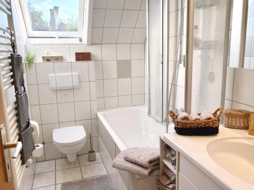 a bathroom with a tub and a toilet and a sink at Naturpause Ferienwohnung in Schmallenberg