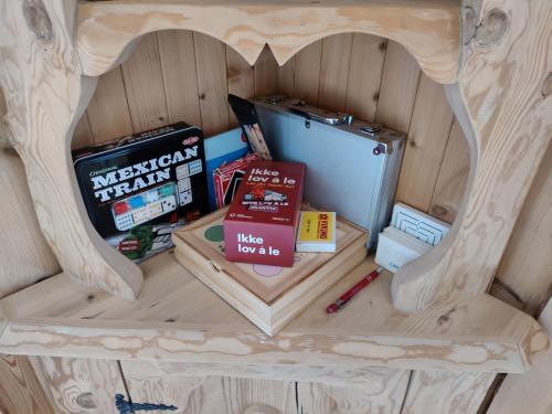 een houten hondenhok met een koelkast en boeken bij Tronstadbu- Traditional cabin in Hellesylt