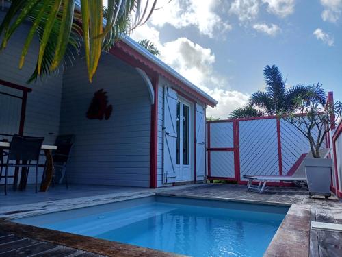 ein Haus mit einem Pool vor einem Haus in der Unterkunft Caraïbes Cottage Grenat piscine privée 900m de Grande anse in Deshaies