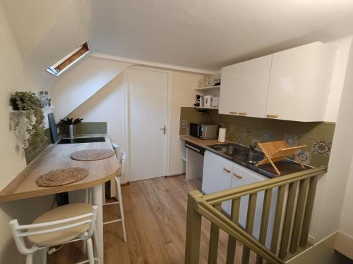 - une petite cuisine avec une table et un comptoir dans l'établissement La Vallée Appartement Proche du Mont Saint Michel, à Roz-sur-Couesnon