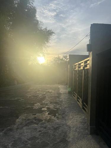 a foggy street with the sun rising behind a building at Keramas temuku family Guest house in Gianyar