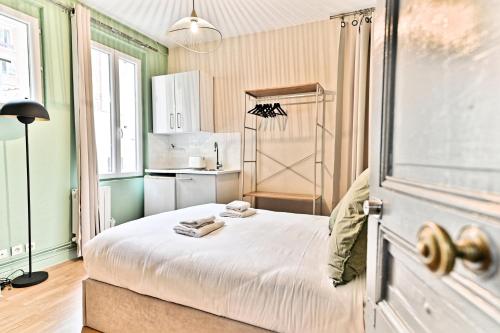 une petite chambre avec un lit et une cuisine dans l'établissement Studio au centre de Paris - 14ème arrondissement, à Paris