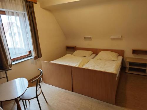 a small bed in a room with a table and a chair at Gasthaus Rotes Ross in Eckental