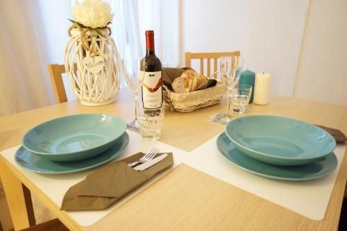 a table with two blue plates and a bottle of wine at B&S Suite Colosseo in Rome