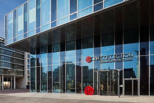 a glass building with a sign on the side of it at NH Collection Frankfurt Spin Tower in Frankfurt/Main