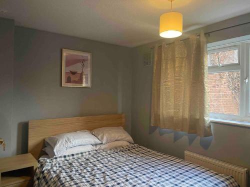 een slaapkamer met een bed en een raam bij Stylish 2 bedroom house Edgware, Barnet in Hendon