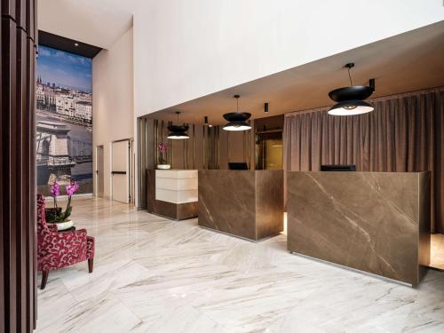 a lobby with a reception desk in a building at NH Collection Budapest City Center in Budapest