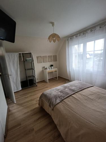 une chambre avec un grand lit et une fenêtre dans l'établissement La Vallée Appartement Proche du Mont Saint Michel, à Roz-sur-Couesnon