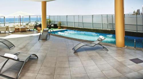 un patio con sillas y una piscina en un edificio en NH Antofagasta, en Antofagasta